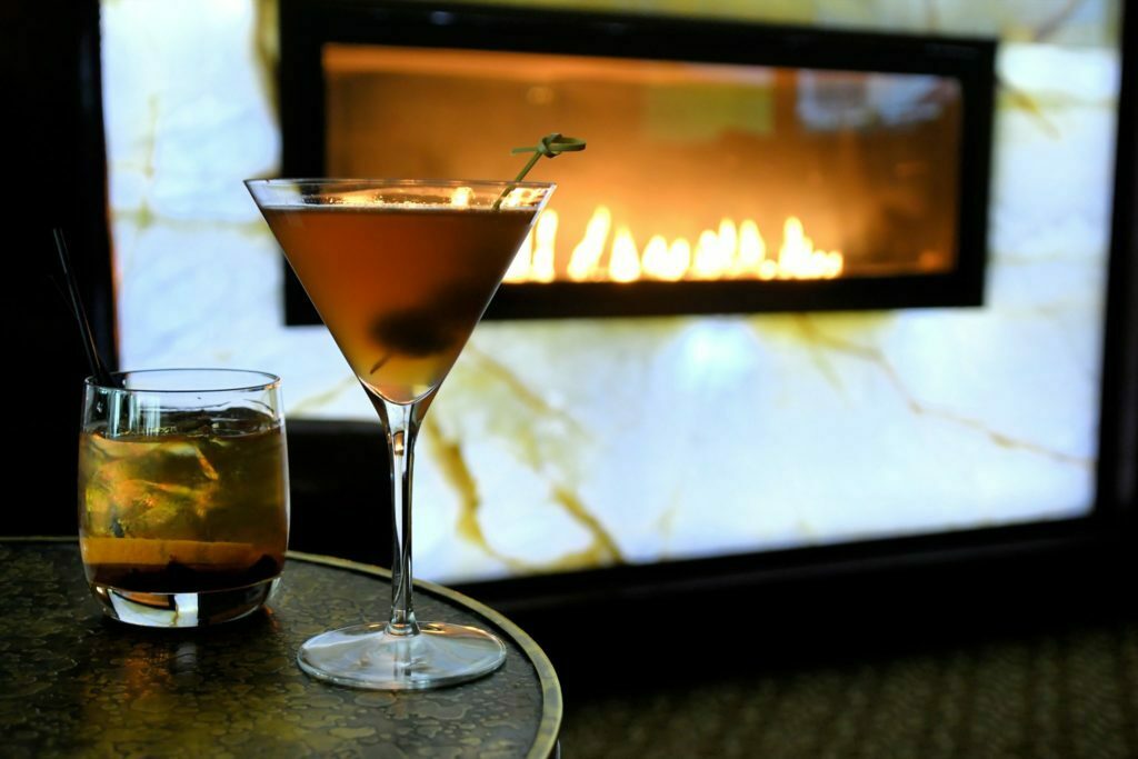 a couple of glasses of liquid next to a television